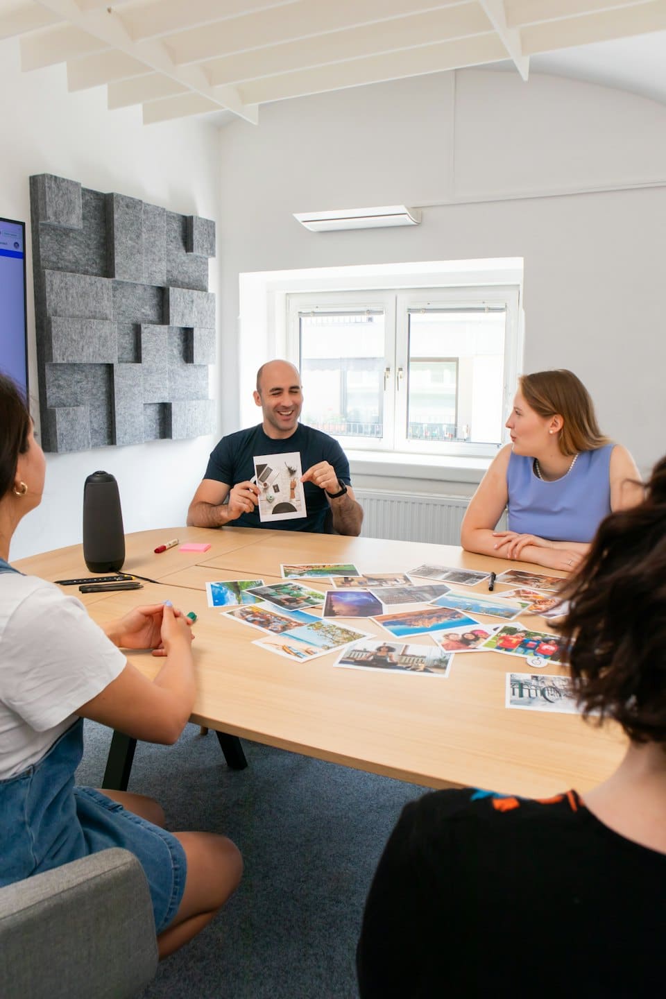 Professionals discuss photos around a conference table.